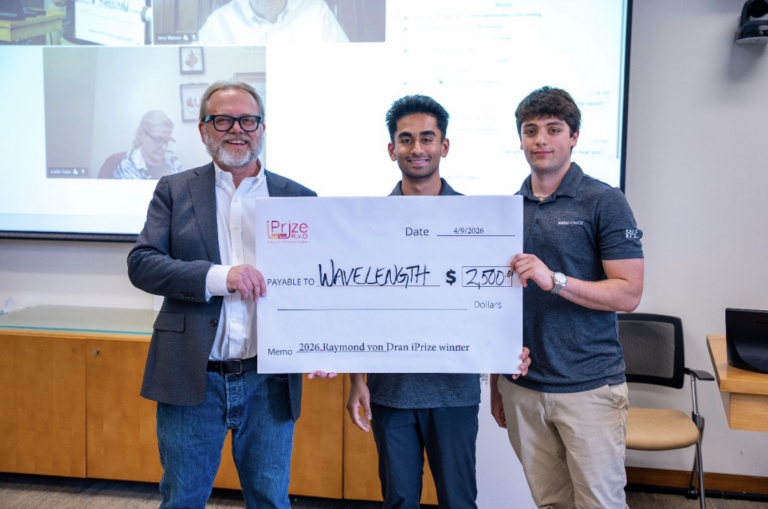Syracuse University seniors Taran Krishnan (center) and Zach Richter (right) are presented with a check following the latest pitch for the NIL agency Wavelength for SU's LaunchPad.